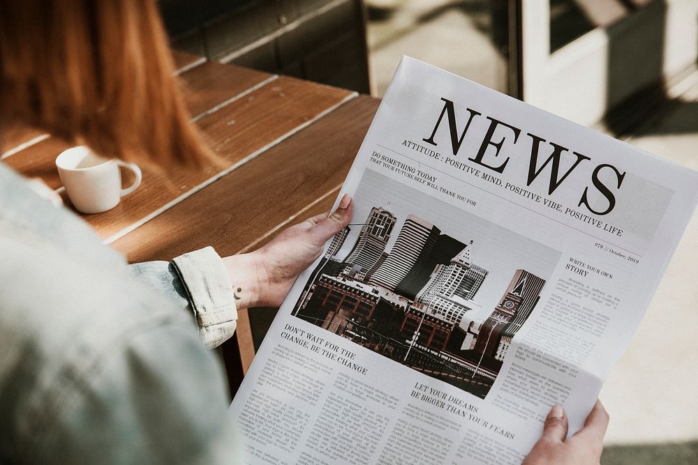 Woman reading a newspaper in a cafe