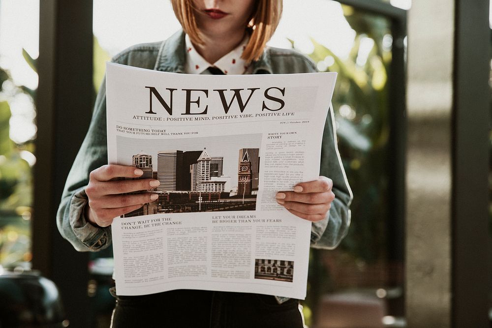 Woman reading a newspaper in a cafe