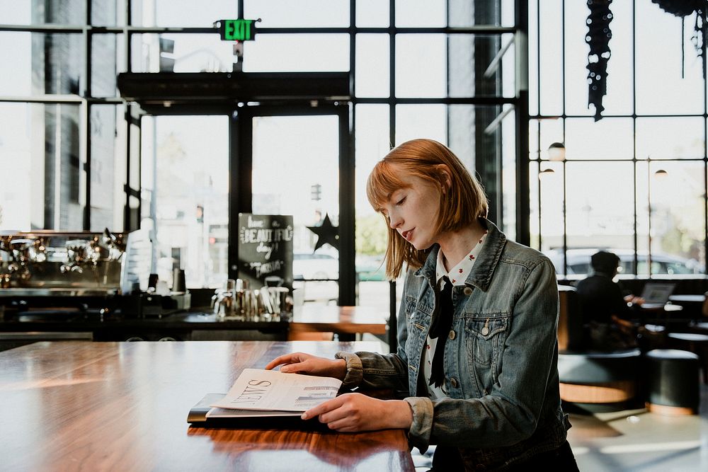 Woman reading a newspaper in a cafe