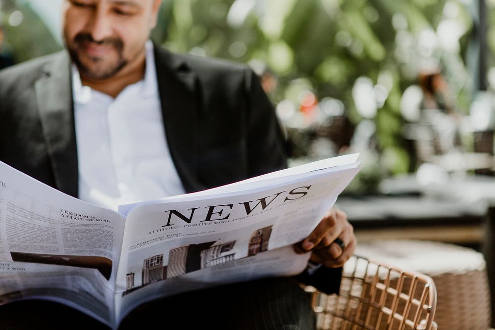 Businessman reading a newspaper in a cafe