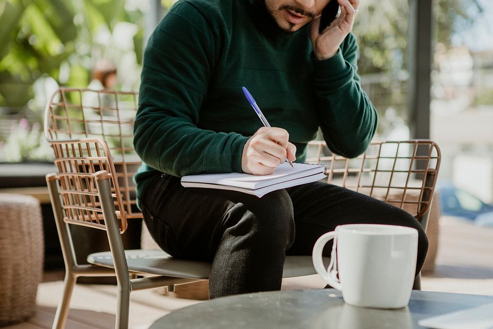 Man taking notes while talking on the phone