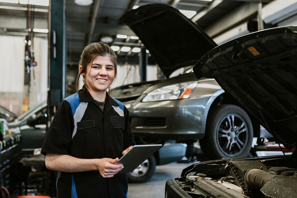 Happy mechanic running a diagnostic on a vehicle