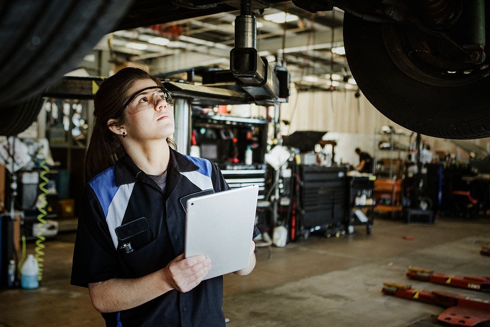 Female mechanic observing a vehicle