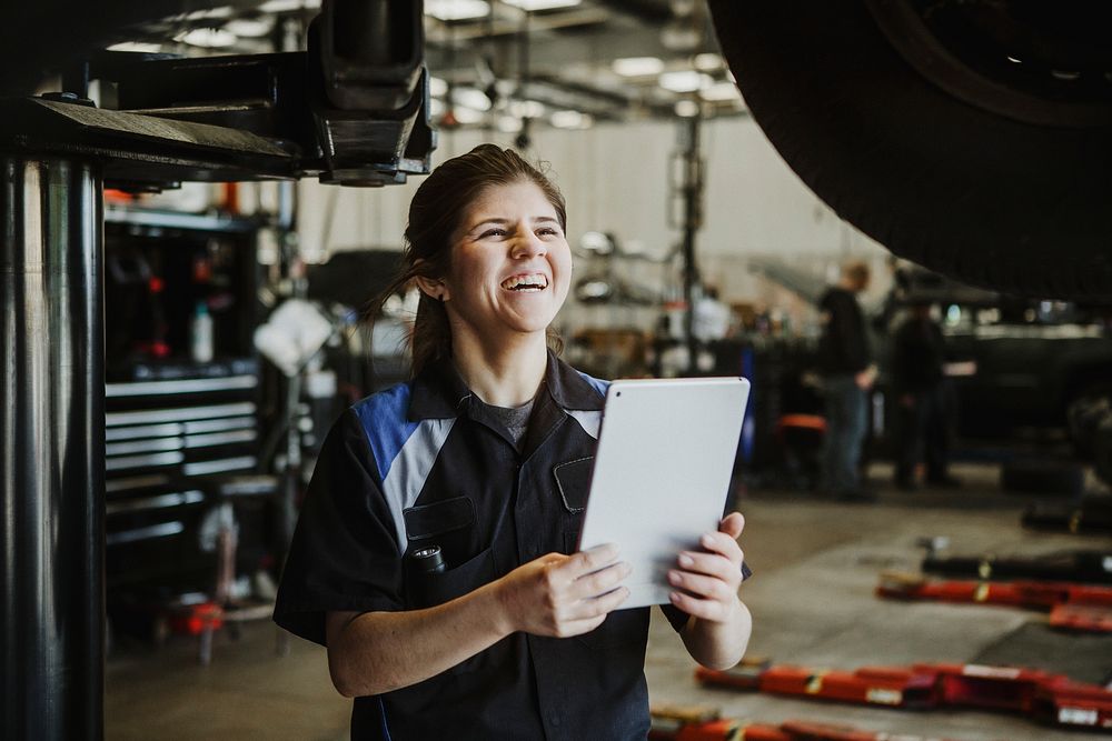 Happy mechanic running a diagnostic on a vehicle