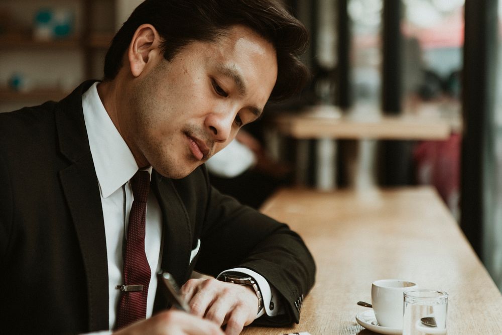 Businessman writing in a cafe