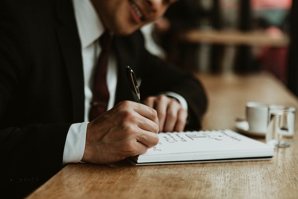 Businessman writing in a cafe