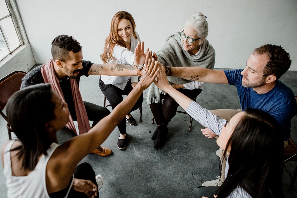 Group of diverse team joining hand in the middle