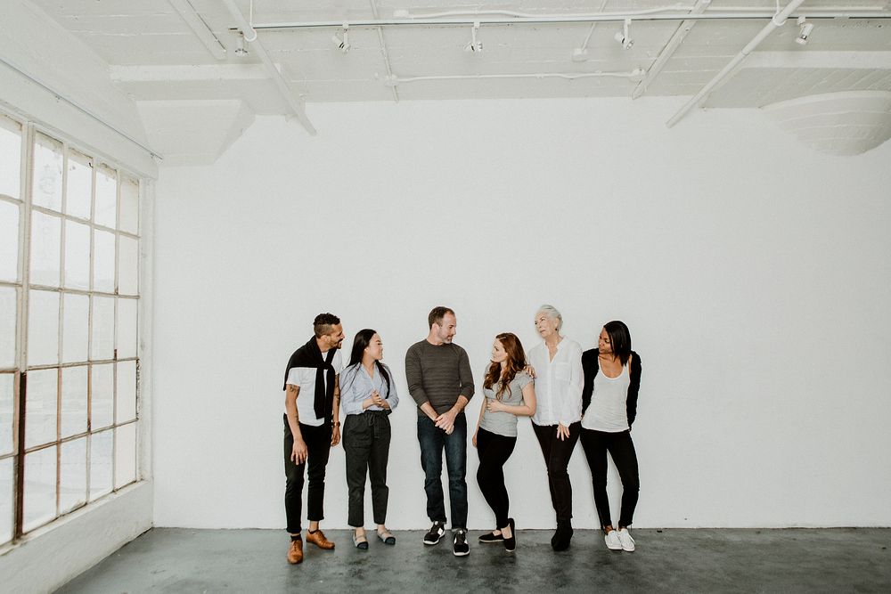 Group of cheerful diverse people talking in a white room