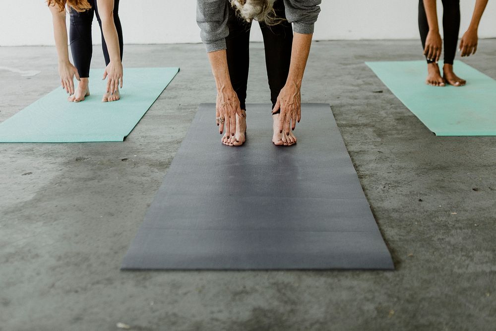 Sporty people practicing Uttanasana pose