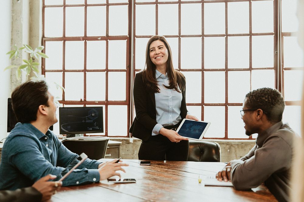 Happy businesspeople in a meeting using a tablet mockup