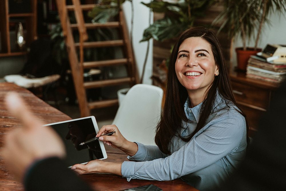 Happy woman in an office with a tablet mockup