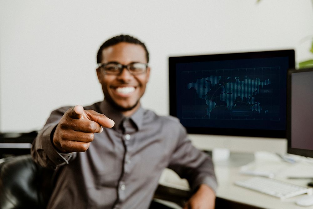 Happy black businessman pointing at the screen