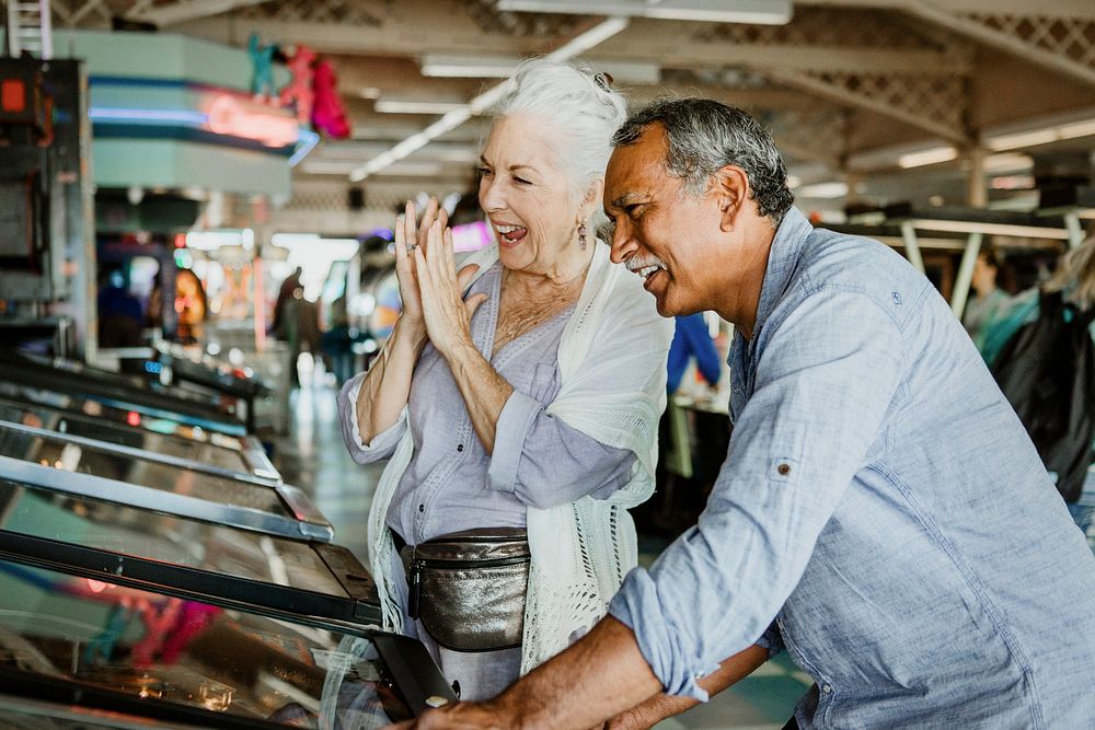 Cheerful senior couple playing games at an arcade