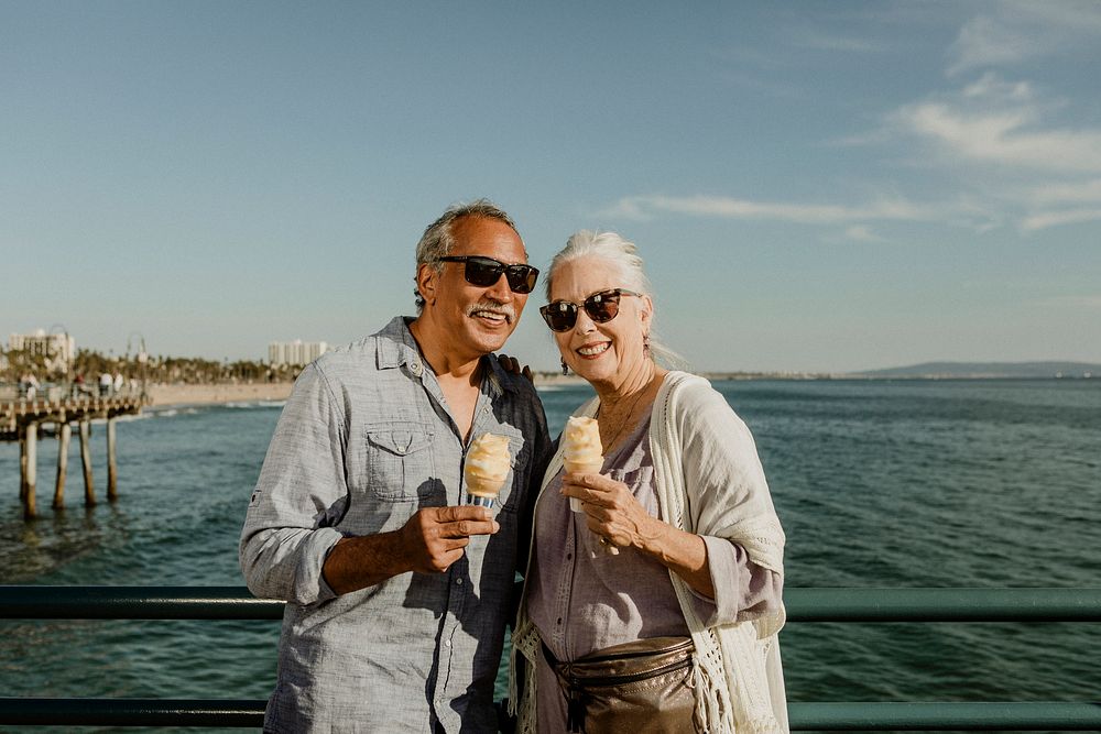 Smiling senior couple with an ice cream cone standing on the Santa Monica Pier