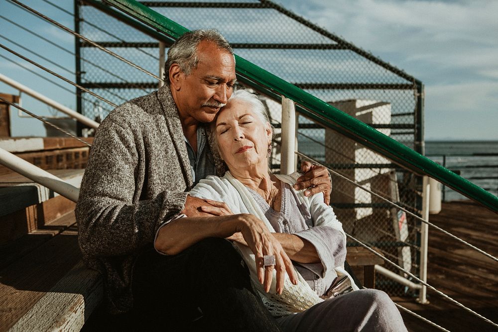 Romantic senior couple sitting on the pier