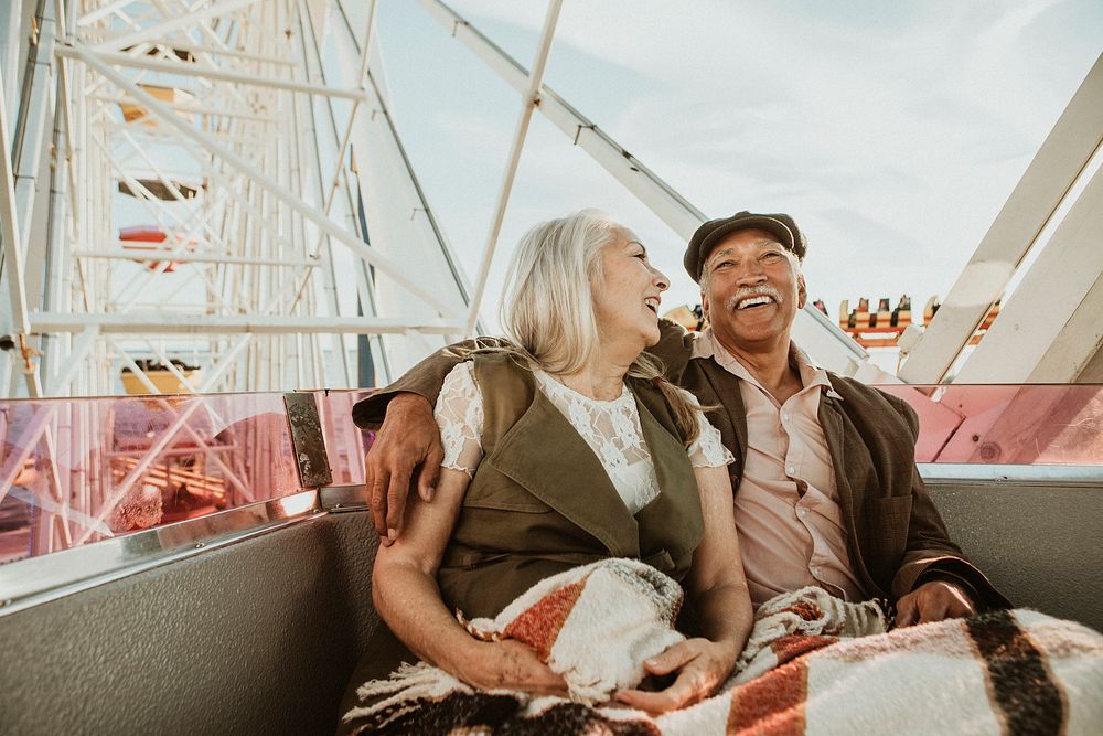 Cheerful senior couple enjoying a Ferris wheel by the Santa Monica pier