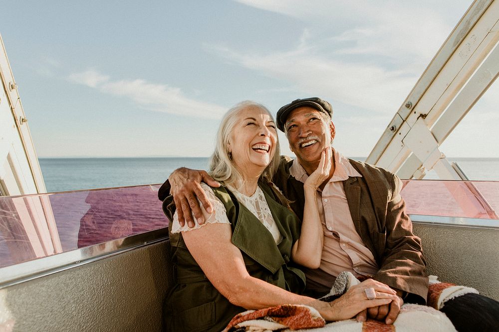 Cheerful senior couple enjoying a Ferris wheel by the Santa Monica pier