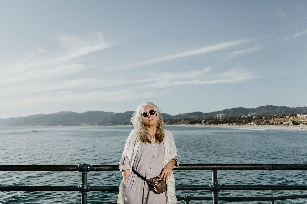 Senior woman standing the by the pier