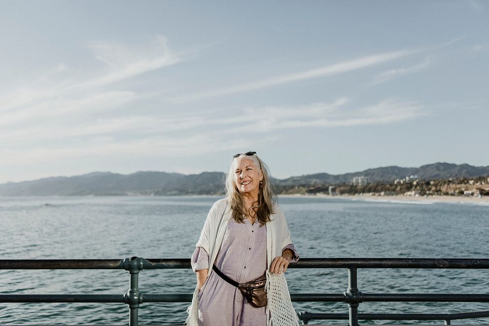 Happy senior woman standing on the pier