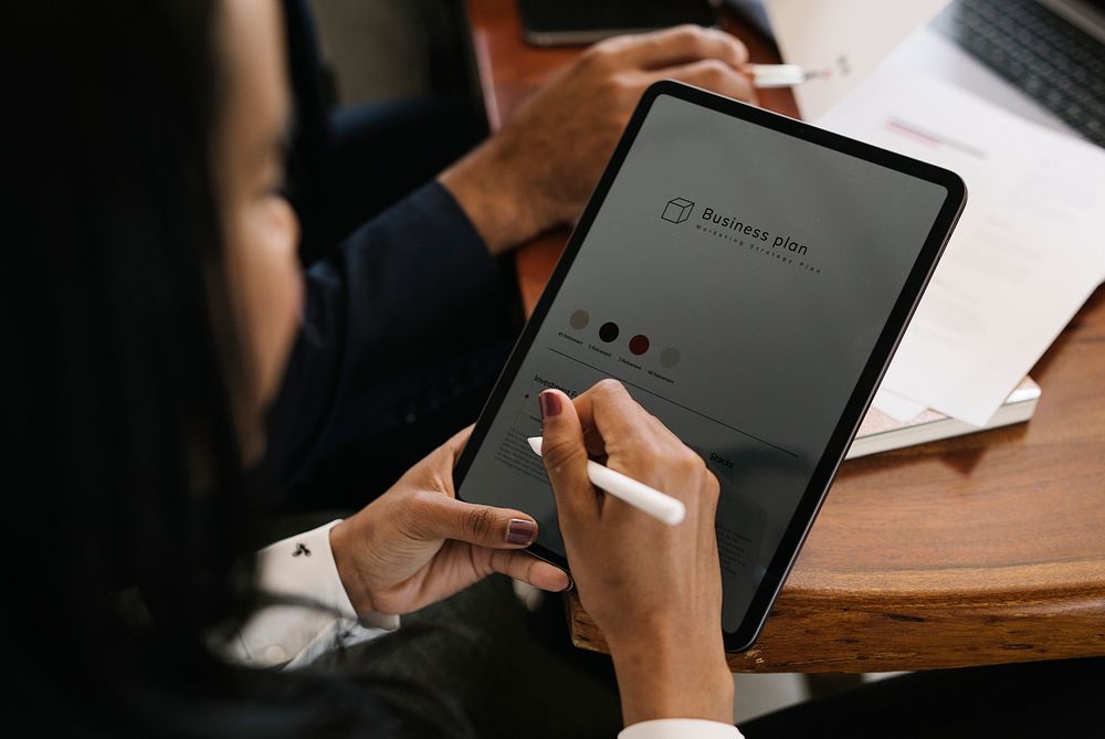 Businessperson taking note on a digital tablet