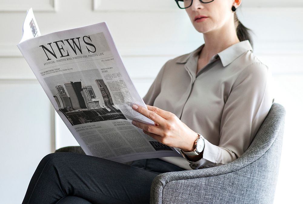 Young businesswoman reading a newspaper