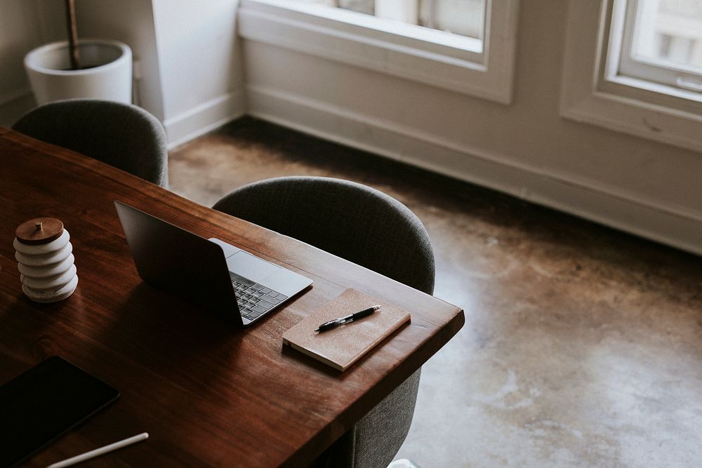 Digital tablet and a laptop on a wooden table in a meeting room