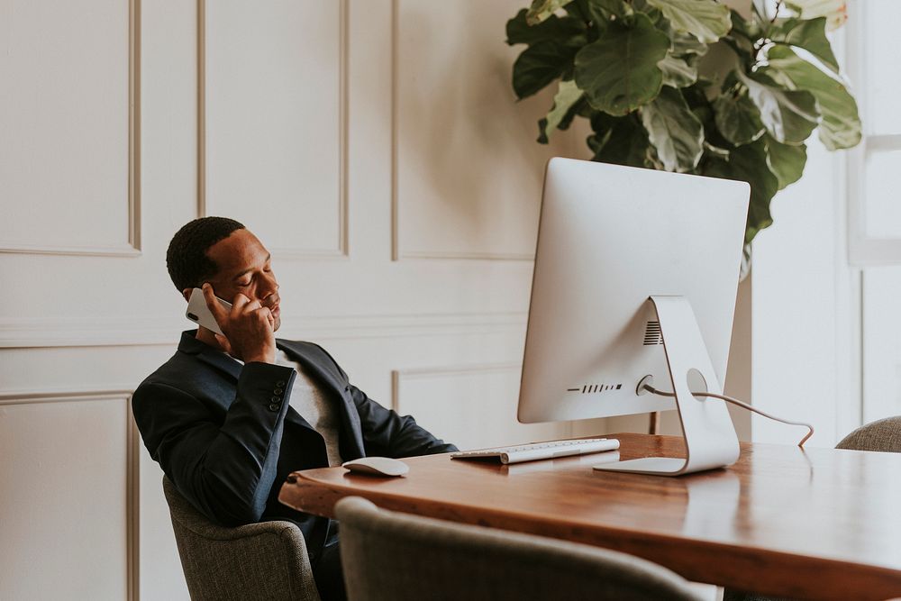 Casual businessman talking on a phone while working in the office