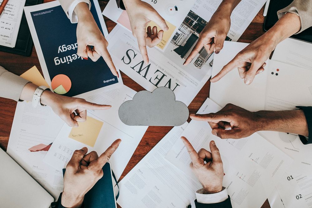 Business people pointing at a blank cloud