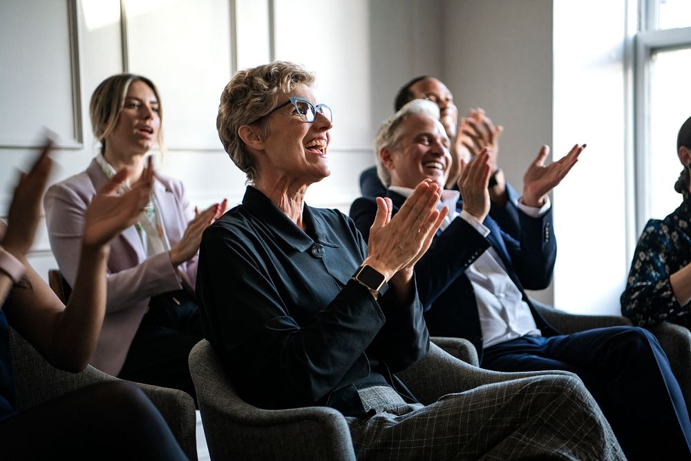 Happy business people applauding in a seminar