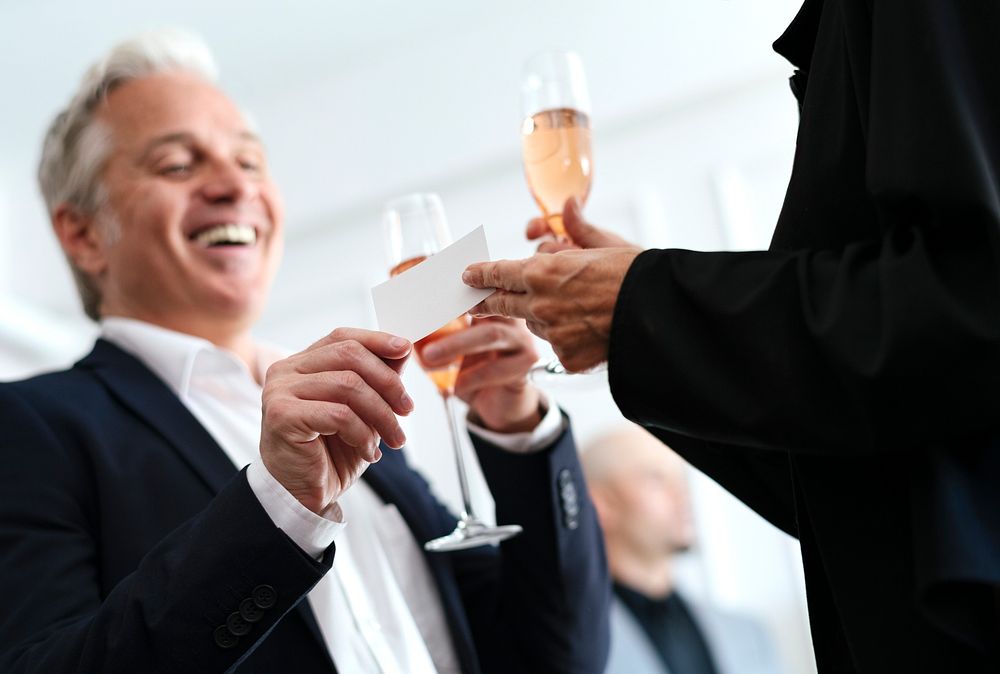 Businessman handing over a business card during a party