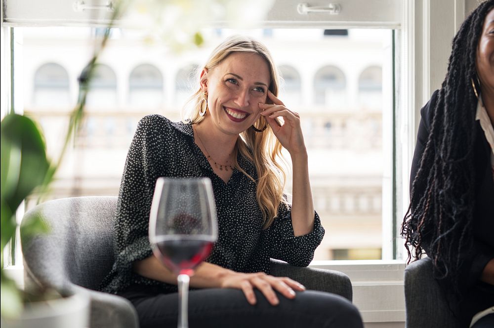 Woman having a glass of red wine with friends