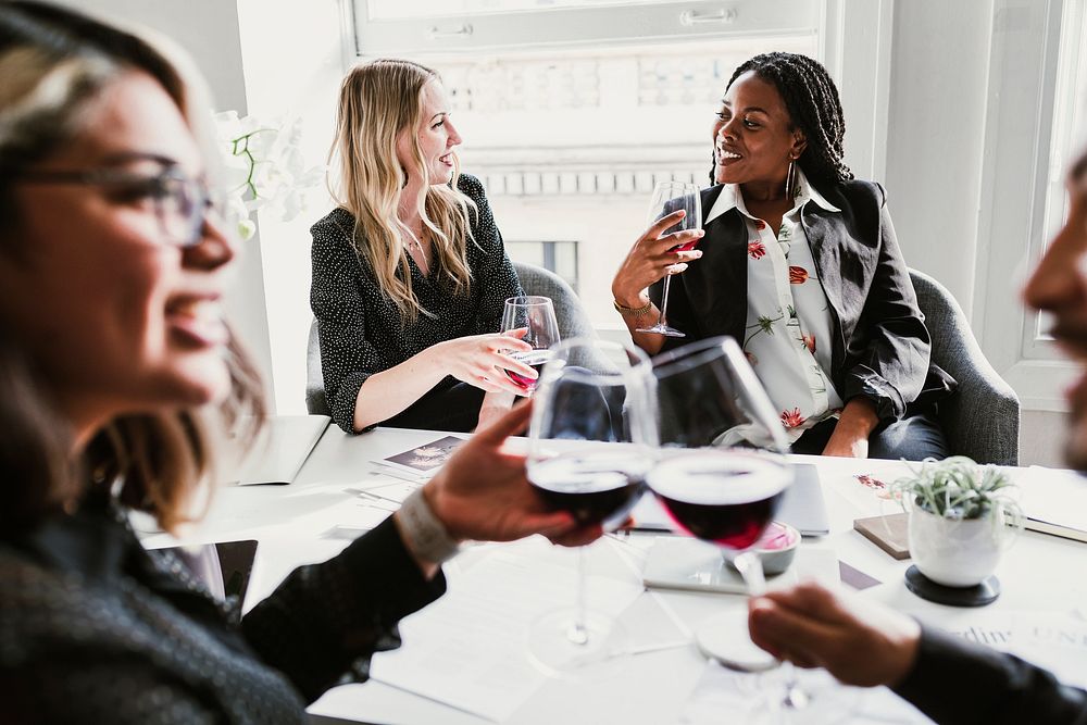 Diverse businesswomen drinking wine in the meeting room