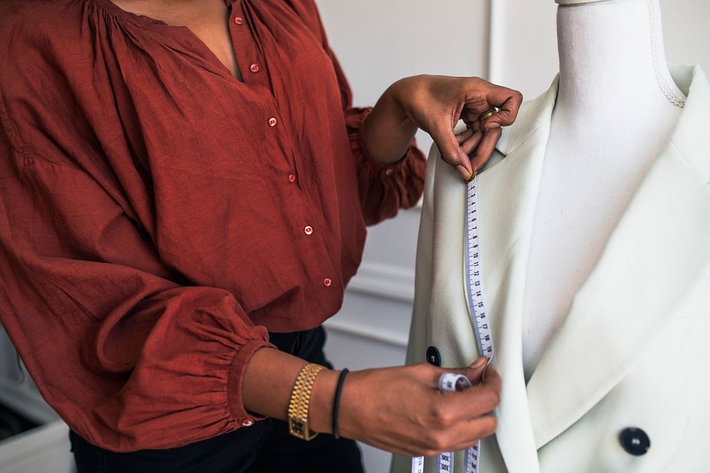 Fashion designer measuring a blazer on a pinnable mannequin