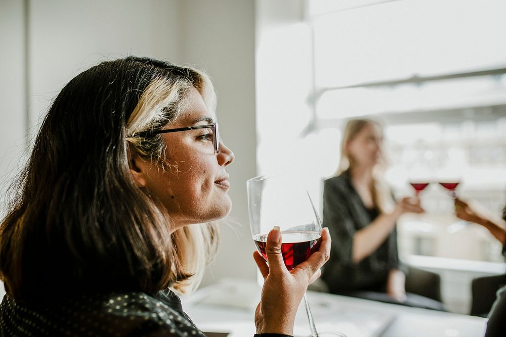 Woman having a glass of red wine with friends