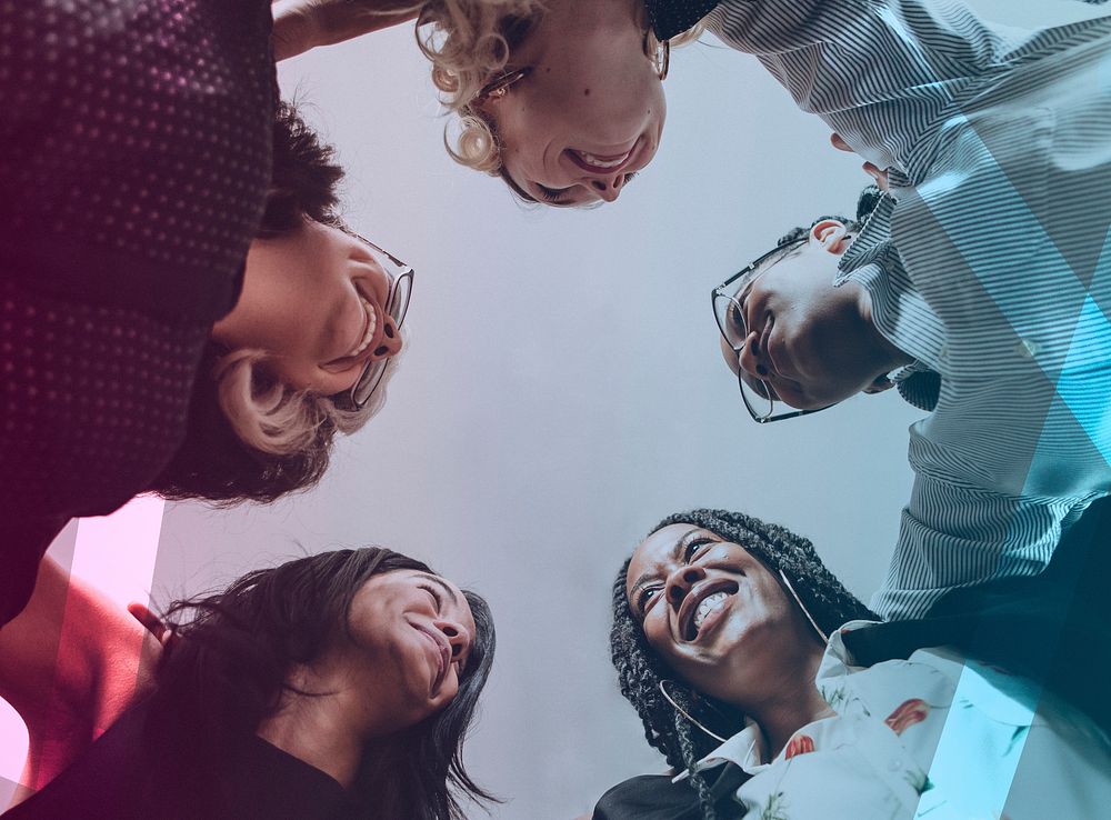 Happy diverse businesswomen huddling in the office