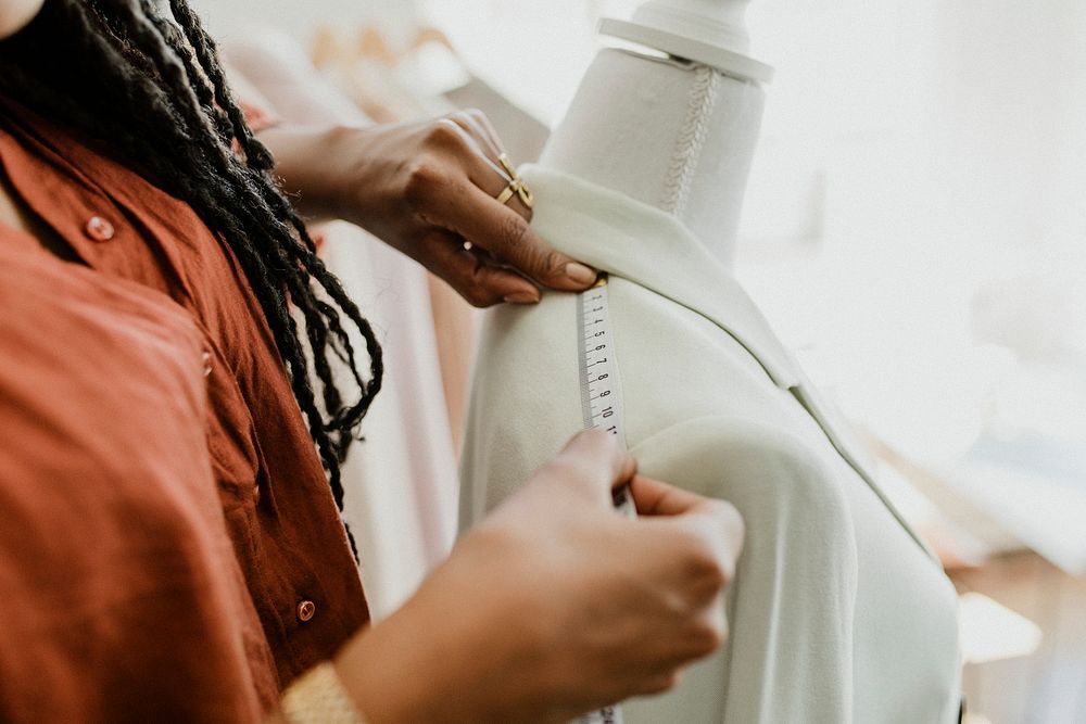 Fashion designer measuring a blazer on a pinnable mannequin
