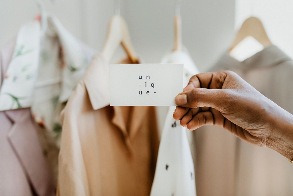 Hand holding business card in a boutique