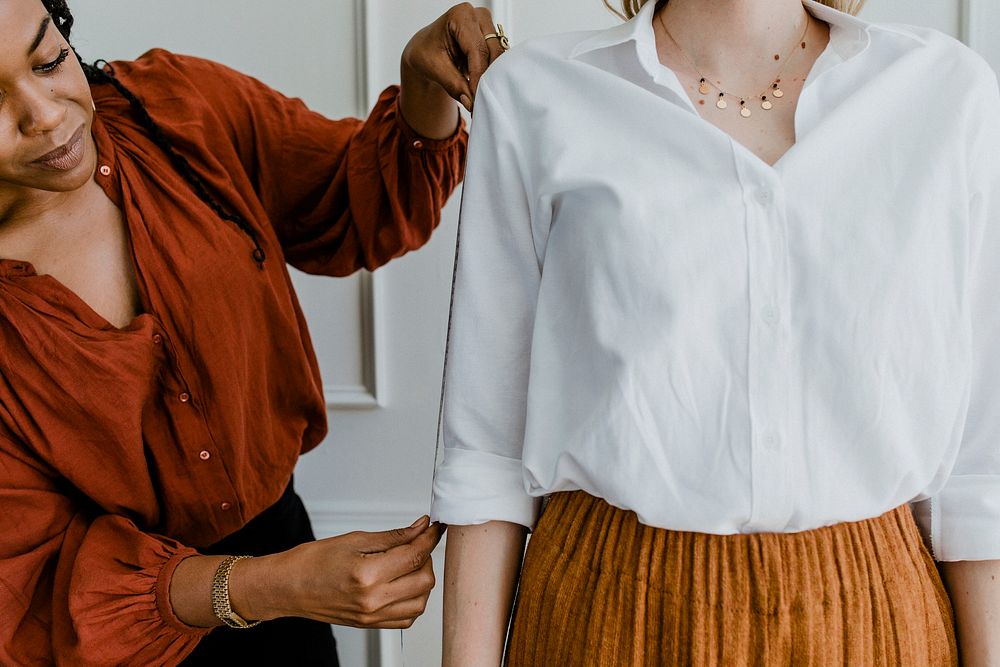 Fashion stylist measuring a customer's arm