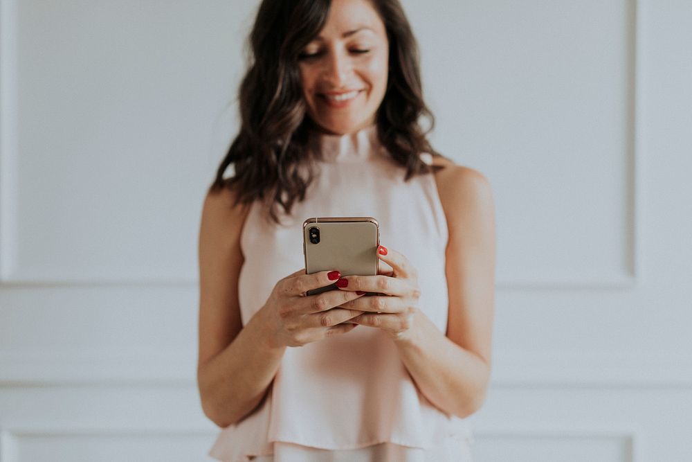 Happy woman playing on her mobile phone