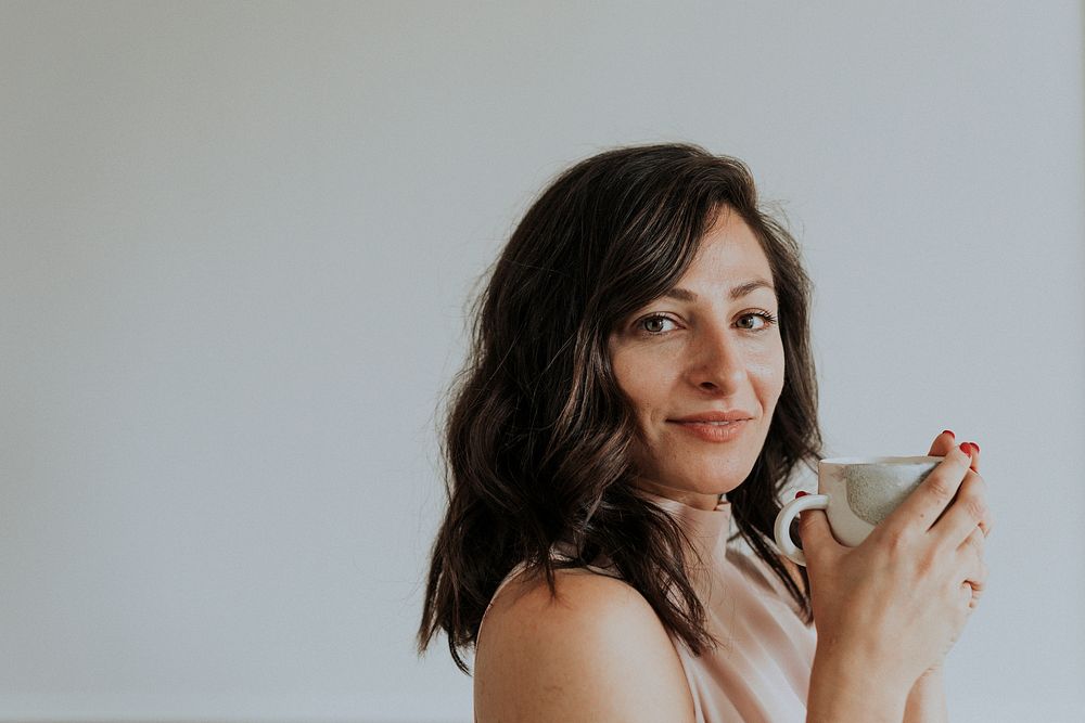 Happy woman holding a cup of coffee