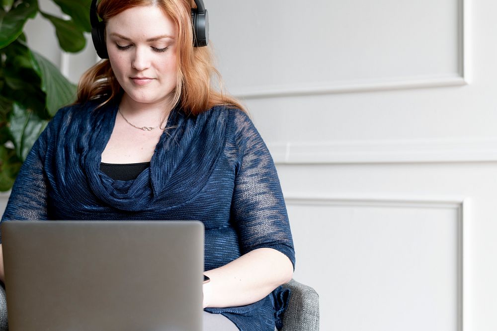 Businesswoman with headphone using a laptop