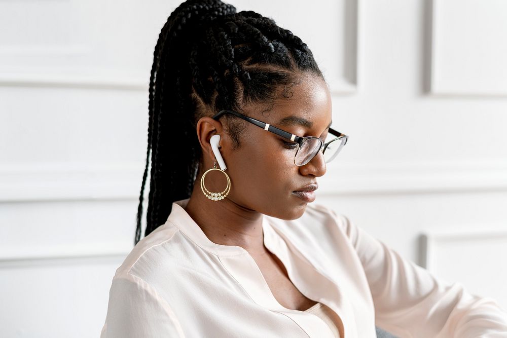 Black woman wearing earphones in the office
