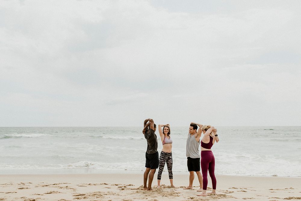 Diverse friends stretching at the beach