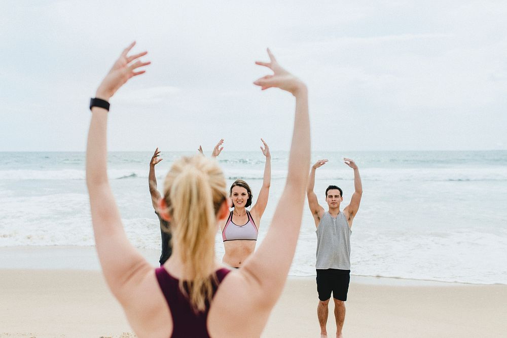 Athletic people stretching at the beach