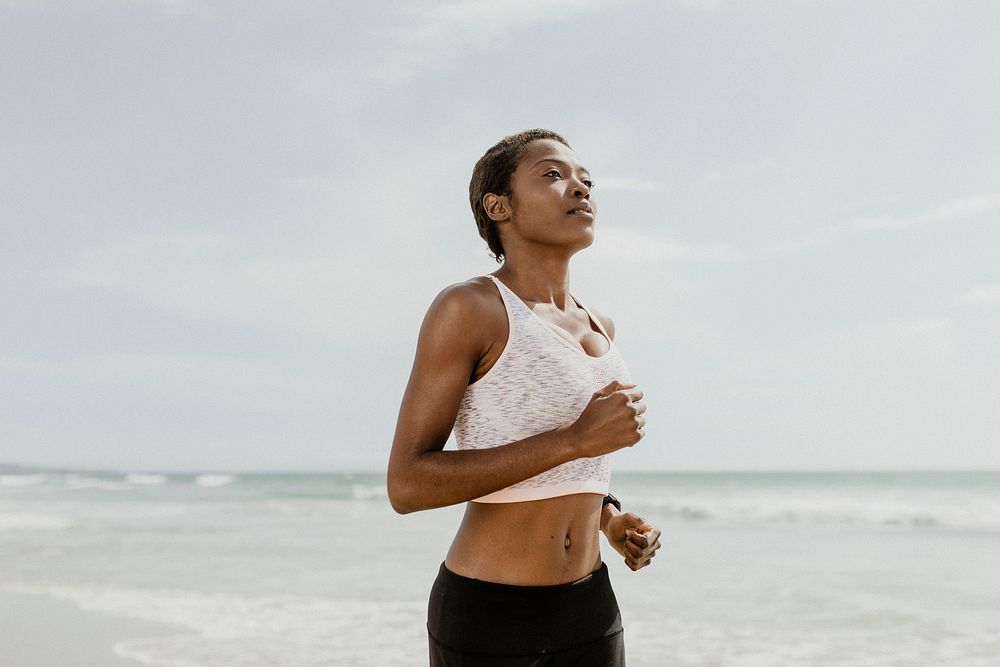 Black woman jogging on the beach