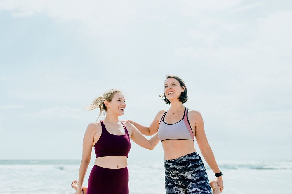 Happy women stretching at the beach