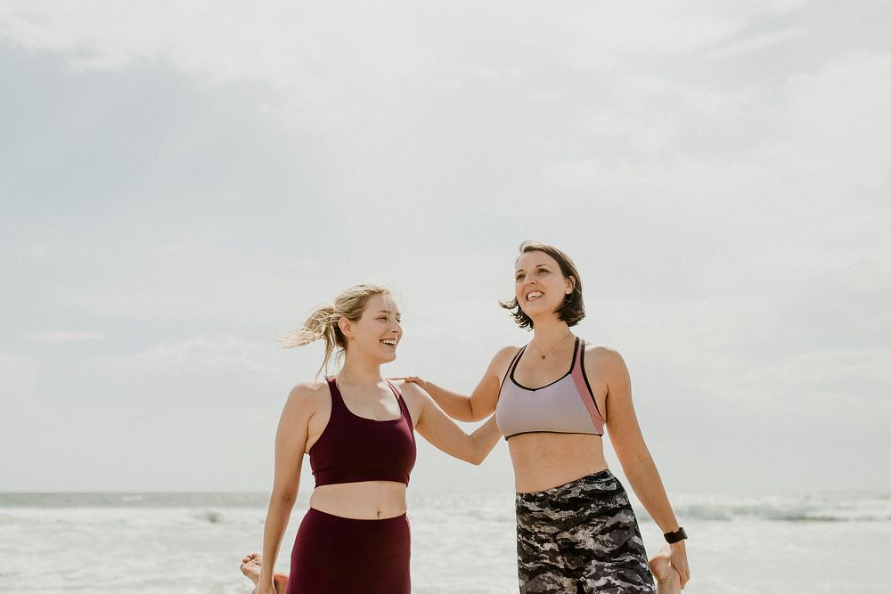 Happy women stretching at the beach