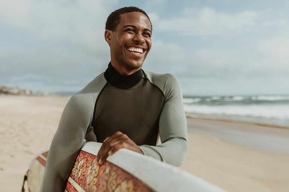 Cheerful man with a surfboard at the beach