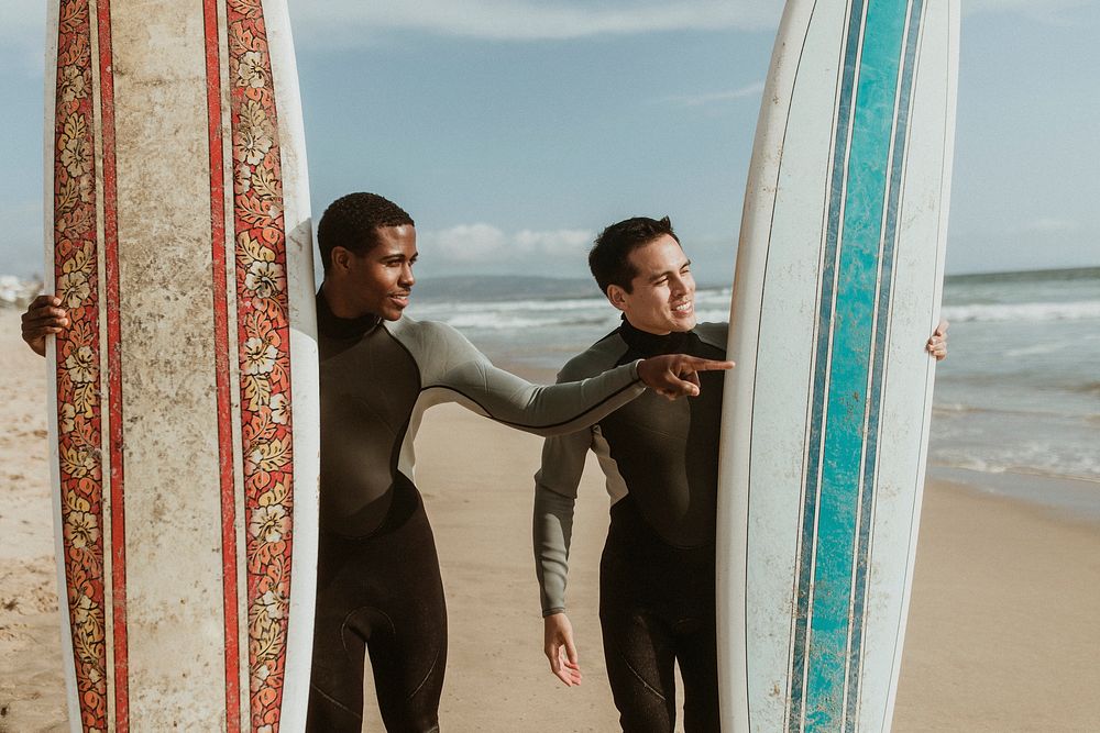 Happy surfer pointing at the sea