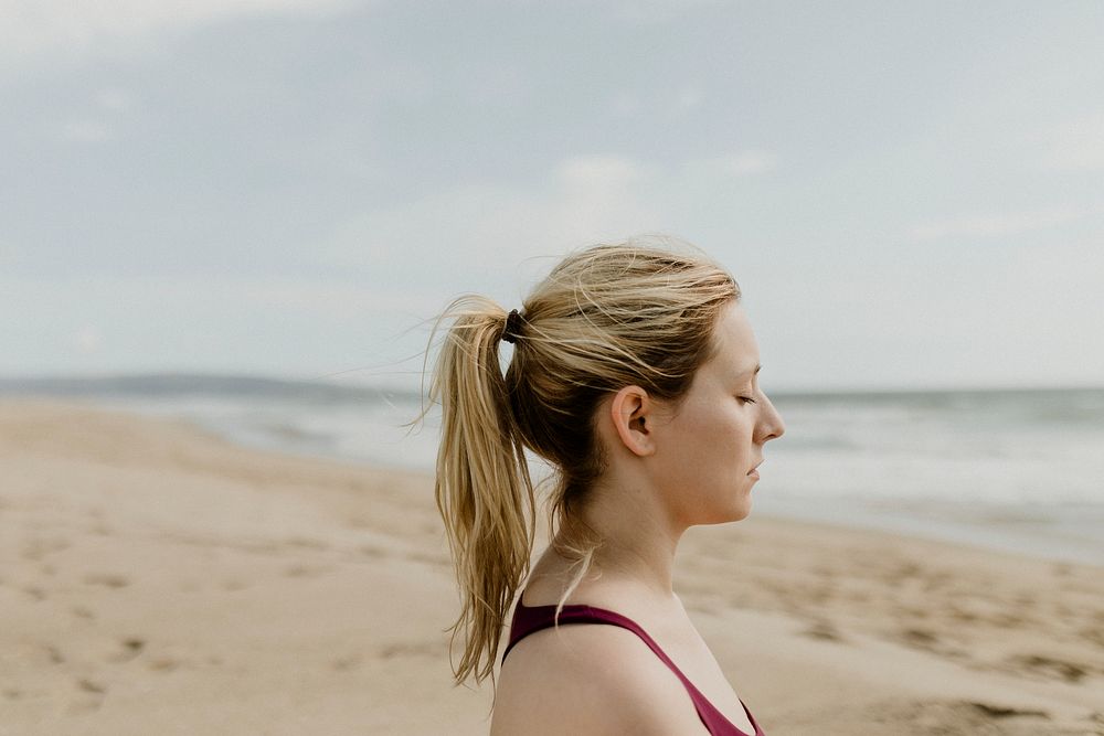 Woman meditating on the beach